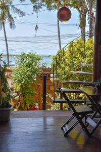 een stoel op een veranda met uitzicht op de oceaan bij Loft Sol Nascente in Itacaré