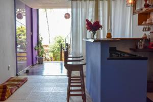 una cocina con barra y un bar con taburete en Loft Sol Nascente, en Itacaré