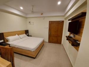 Kama o mga kama sa kuwarto sa Hotel Sree Gokulam Apartments