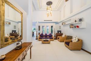 una sala de estar con un espejo grande y sofás en Villa Pimmada, en Ao Nang Beach