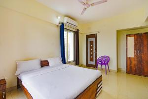 a bedroom with a bed and a purple chair at FabExpress Golden Leaf Airport in Pune