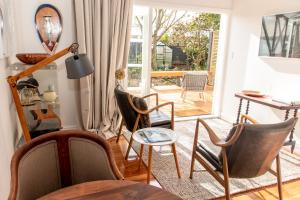 CartertonThe Alchemist Retreat, Private Studio in Carterton的客厅配有椅子和桌子