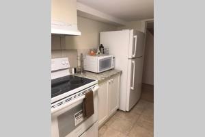 een keuken met witte apparatuur en een witte koelkast bij Tastefully decorated spacious apartment Burlington in Burlington