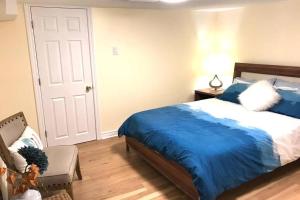 een slaapkamer met een blauw bed en een stoel bij Tastefully decorated spacious apartment Burlington in Burlington