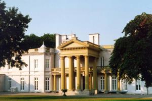 een groot wit huis met zuilen op een gazon bij Tastefully decorated spacious apartment Burlington in Burlington