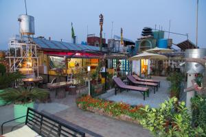 an outdoor patio with benches and tables and umbrellas at Hotel Utse in Kathmandu