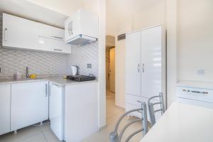 a white kitchen with white cabinets and chairs at Apartments Near to City Center and Beach in Marmaris