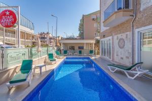 a swimming pool with lounge chairs and a hotel at Apartments Near to City Center and Beach in Marmaris