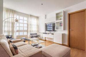 ein Wohnzimmer mit Sofa und Tisch in der Unterkunft Precioso apartamento nuevo en el centro de A Coruña! in A Coruña