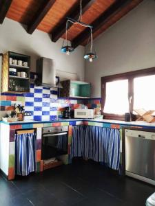 a kitchen with colorful tiles on the wall at En Huerto de Catalina in Fuentes de Béjar