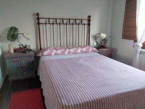 a bedroom with a large bed with a striped blanket at En Huerto de Catalina in Fuentes de Béjar