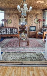 a living room with a couch and a table at Jackson Heights Houseboats in Srinagar