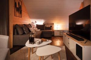 ein Wohnzimmer mit einem Sofa und einem Tisch in der Unterkunft Duplex La Vue du Lac in Malbuisson