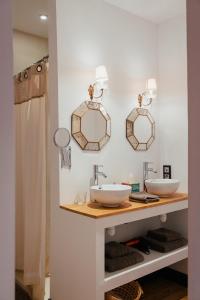 ein Bad mit 2 Waschbecken und Spiegeln an der Wand in der Unterkunft Villa 2 Pas Sages in La Roche-Chalais