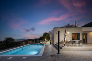 a house with a swimming pool at night at Villa Castanea in Opatija