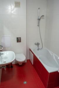 a bathroom with a toilet and a tub and a sink at Central Apartment Mountain View in Karlovo