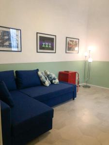 un soggiorno con divano blu e valigia rossa di Caves Apartment a Bari
