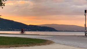a person riding a bike on the beach at sunset at chambre atypique à 200m du lac in Saint-Jorioz