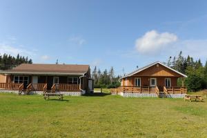 a house with benches in front of a yard at Riverside Chalets in River of Ponds