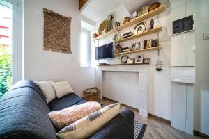 uma sala de estar com um sofá azul e uma cozinha em Le Boheme - Rent4night Grenoble em Grenoble