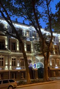 un bâtiment avec une voiture garée devant lui dans l'établissement Queen Valery Hotel, à Odessa