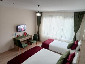 a hotel room with two beds and a desk at KURT OTEL in Degirmen