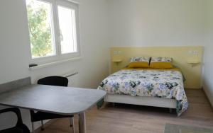 a small bedroom with a bed and a table at Chez Fabrice in Gunstett