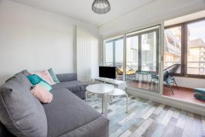 a living room with a couch and a table at Les Sardines in Courseulles-sur-Mer