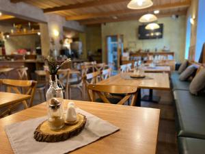 a restaurant with a table with a bottle and a pair of shoes at Resort Pasečná in Přední Výtoň