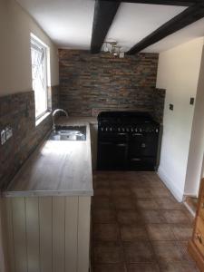 a kitchen with a sink and a stove at Whitehouse Cottage - Great Paxton in Saint Neots