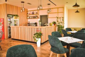 un restaurant avec des chaises, des tables et un comptoir dans l'établissement Airport Garden Hotel, à Rinas