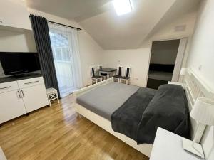een slaapkamer met een groot bed en een tafel met stoelen bij Martinske Hole, Apartman, Nova Ponorka in Martin