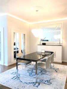 une salle à manger avec une table noire et des chaises blanches dans l'établissement MONDRIAN Luxury Suites UNESCO Old Town, à Varsovie