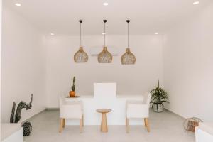 a white room with chairs and a table and pendant lights at RAW BEACH HOTEL in Antalya