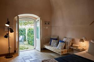 a bedroom with a bed and a couch and an open door at Borgo San Gaetano in Bernalda