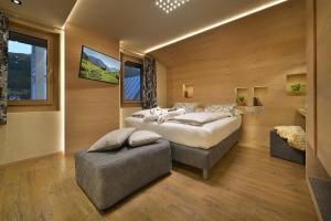 a large bedroom with a large bed and a chair at Hotel Compagnoni in Livigno