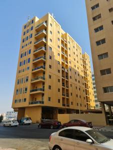 żółty budynek z samochodami zaparkowanymi przed nim w obiekcie Dubai Hostel, Bedspace and Backpackers w Dubaju