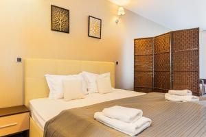 a bedroom with a bed with two towels on it at Pine Woods Studio D113 in Silver Mountain in Poiana Brasov +42 photos