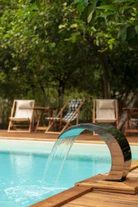 a water fountain in front of a swimming pool at Gayb-i Bungalows by Naturelife - Free Access to Beach & Naturelife Spa in Cıralı