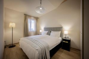 ein Schlafzimmer mit einem großen weißen Bett und einem Fenster in der Unterkunft Hotel Bruneck Design-Apartments in Bruneck