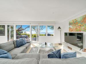 a living room with a couch and a tv at On The Beach at Vincentia in Vincentia