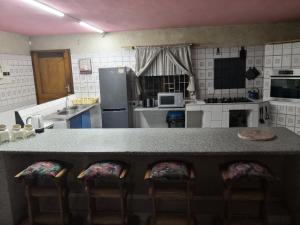 a kitchen with a counter with chairs in it at Oupie-se-Plekkie in Velddrif