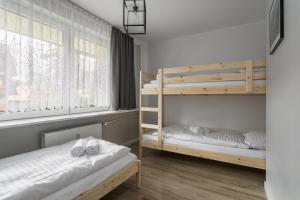 a bedroom with two bunk beds and a window at Rent like home - Żeromskiego 10 in Zakopane