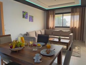 een woonkamer met een tafel en een bank bij Appart AYAMOUS MARINA in Kenitra