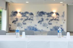 two bottles of water sitting on top of a table at Hôtel Les Grenettes in Sainte-Marie-de-Ré