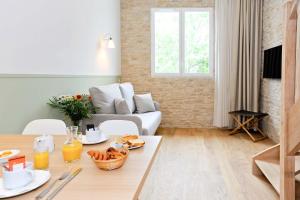 a living room with a table and a couch at Hôtel Les Grenettes in Sainte-Marie-de-Ré