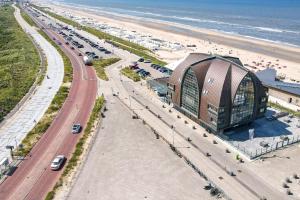 an aerial view of a building next to a beach at Appartement met zeezicht in Bloemendaal in Bloemendaal