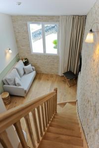 a living room with a white couch and a staircase at Hôtel Les Grenettes in Sainte-Marie-de-Ré