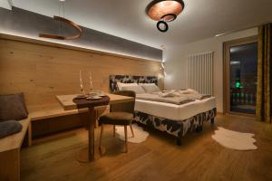 um quarto com uma cama, uma mesa e um sofá em Hotel Compagnoni em Livigno