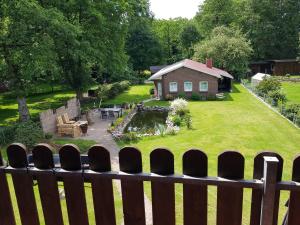 Blick auf einen Hinterhof mit einem Haus und einem Teich in der Unterkunft Ferienwohnung Dustin in Neuenkirchen